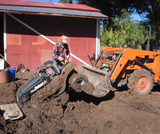 Doug chains up a lawn mower so that it can be pulled from the mud.